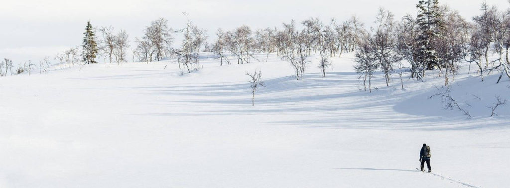 skier crossing a mountain snow field